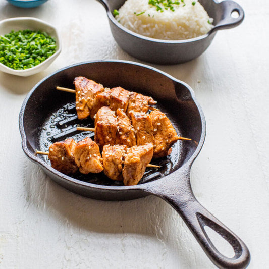 Sesame chicken skewers freshly made and served on pan.