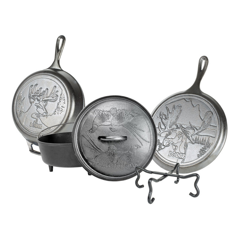 Set of a skillet, griddle, and camp dutch oven with animal designs, along with a tool for camp cooking.