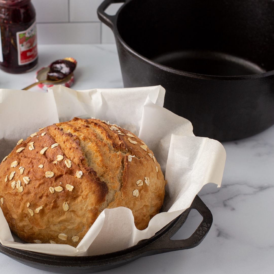 Freshly baked bread, prepared in dutch oven using the lid as the base and dutch oven portion as a dome to facilitate removing hot bread.