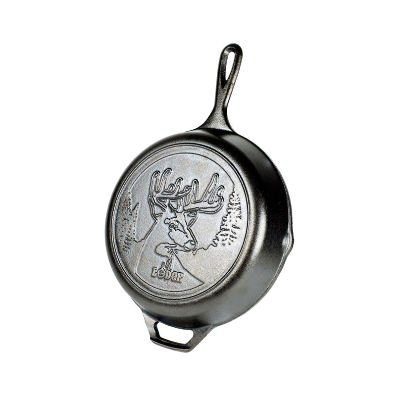 Cast iron skillet with embossed design featuring a deer with antlers in a forest.