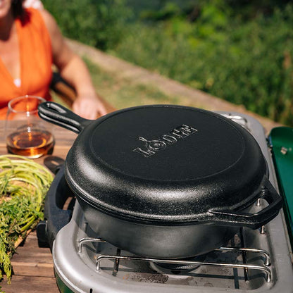 Combo cooker being used on a portable burner outside.
