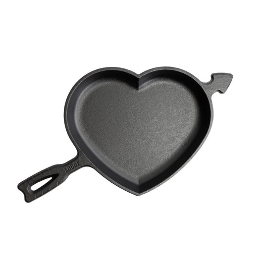 A black heart-shaped cast iron skillet with a handle and arrow design.