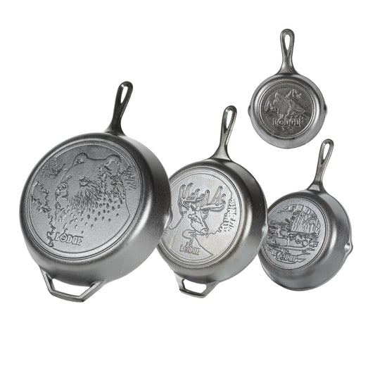 Set of four Lodge cast iron skillets with engraved designs of wildlife on the back of each skillet.