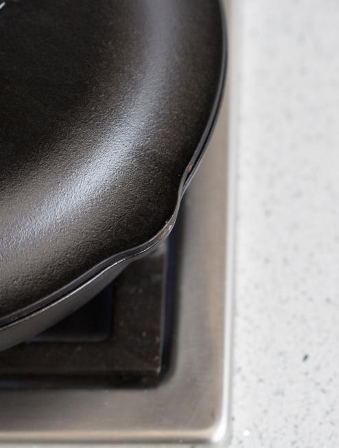 Close-up view of lid showing the lid is shaped to cover pour spout on skillet.
