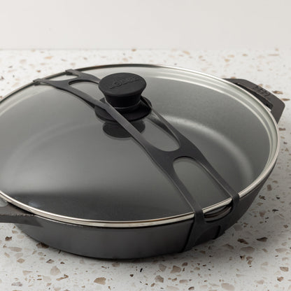 Close up shot of black lid latch being used on our everyday pan and glass lid.