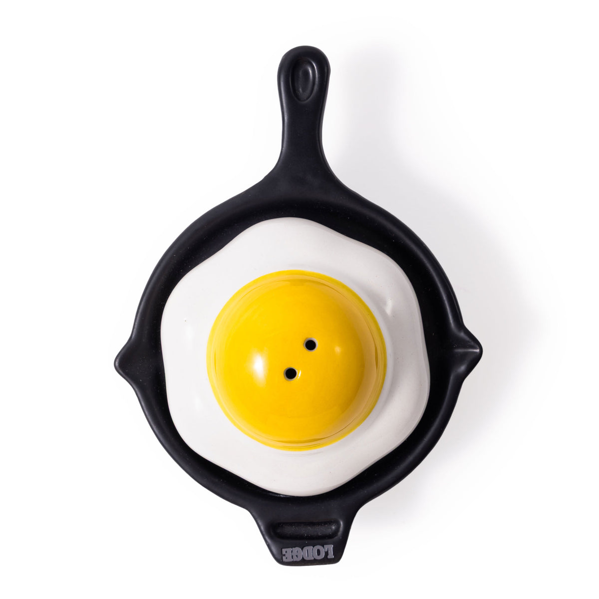 Black frying pan with a fried egg design on a white background