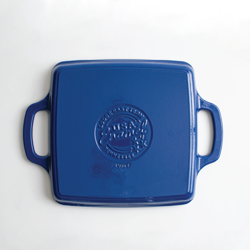 View of bottom of grill pan featuring an engraved Lodge Cast Iron USA Enamel logo.
