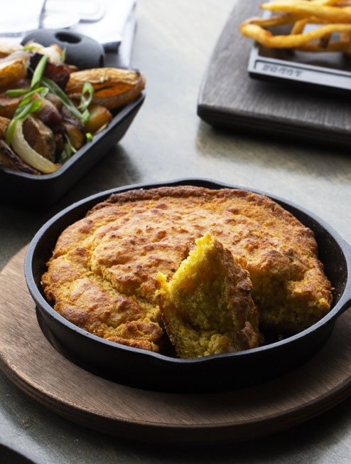 Fresh cornbread served in skillet on underliner.