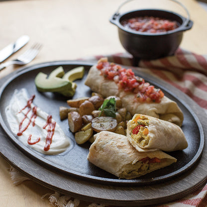 Breakfast burritos and potatoes served on griddle with underliner.