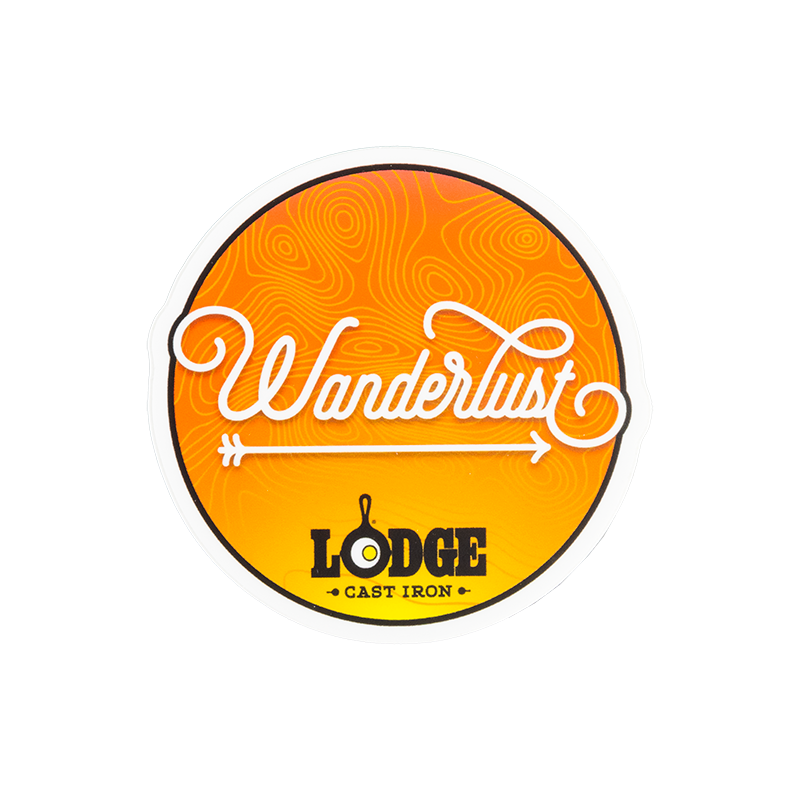 An orange sticker with Wanderlust written in a cursive font, an arrow, and Lodge logo.