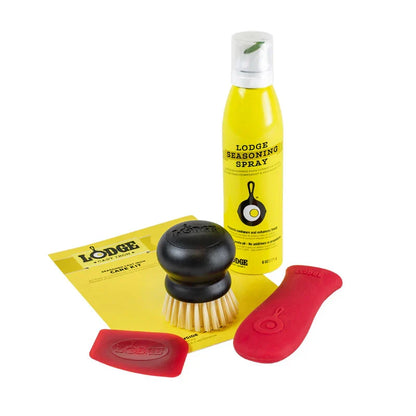 4 piece care set with a red silicone handle holder, red scraper, black scrub brush, and a bottle of seasoning spray.