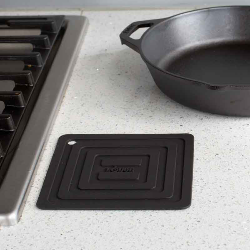 Potholder laying flat on kitchen counter next to stove.