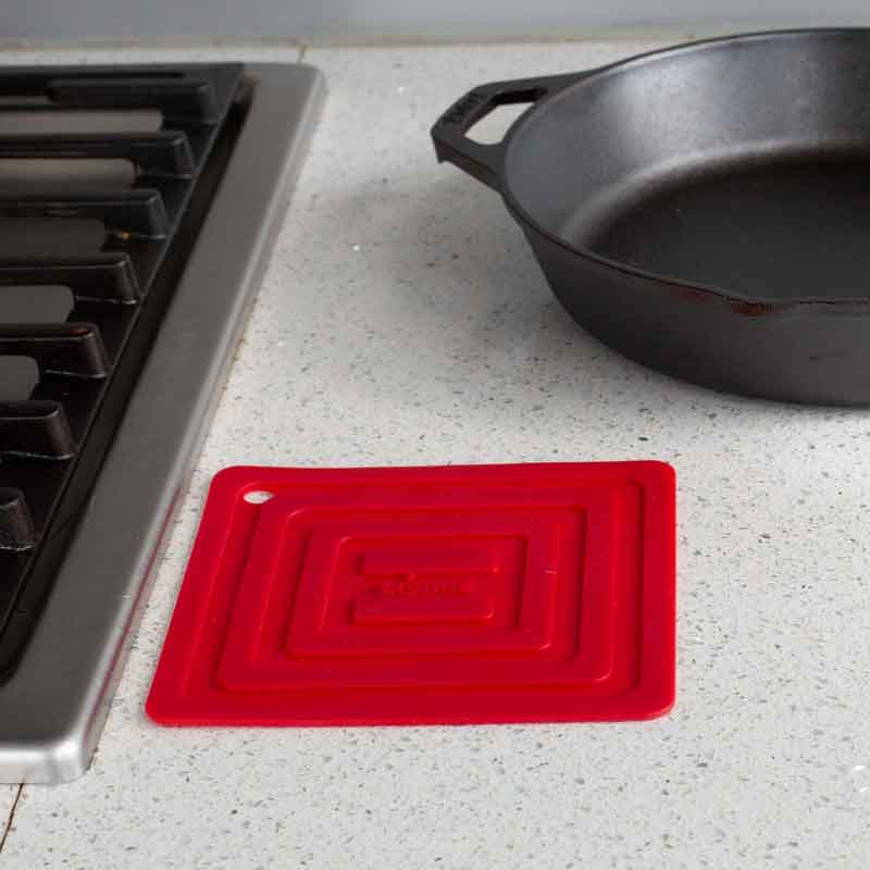 Potholder laying flat on kitchen counter next to stove.