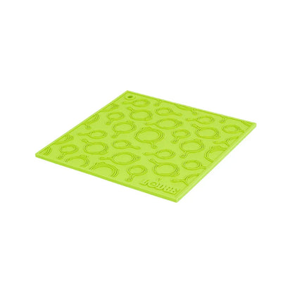 Green silicone trivet with embossed Lodge skillets scattered throughout surface.
