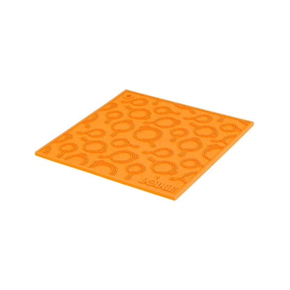 Orange silicone trivet with embossed Lodge skillets scattered throughout surface.
