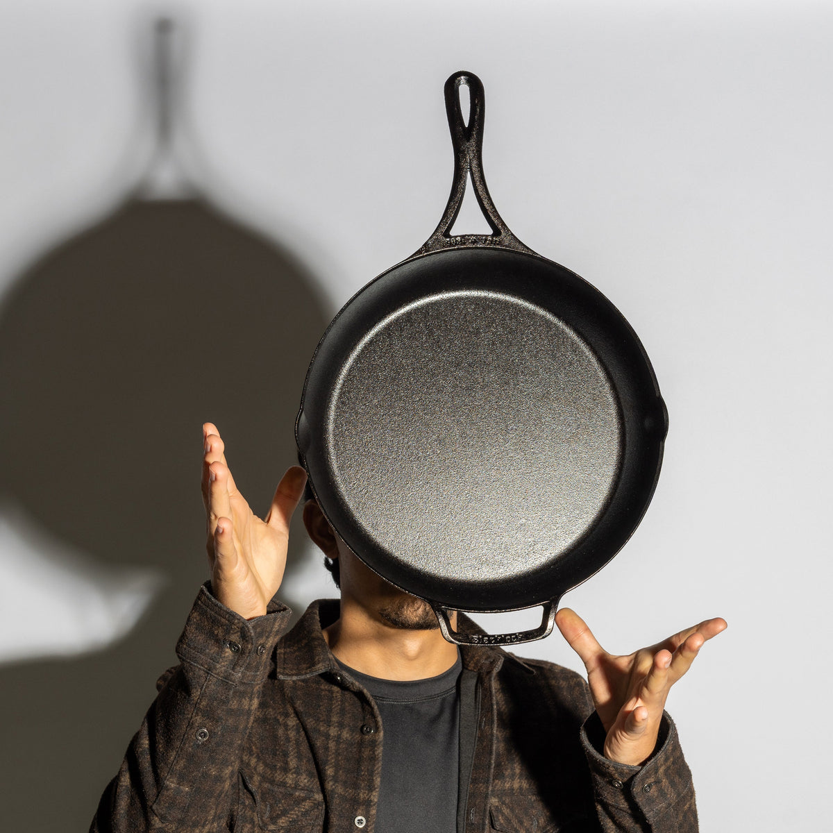 Someone tossing skillet in air showing cooking surface and how it's lightweight.