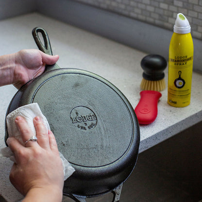 Someone rubbing in the seasoning spray oil on their clean cast iron skillet.