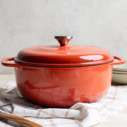 Enameled cast iron Dutch oven on a white towel with a neutral background
