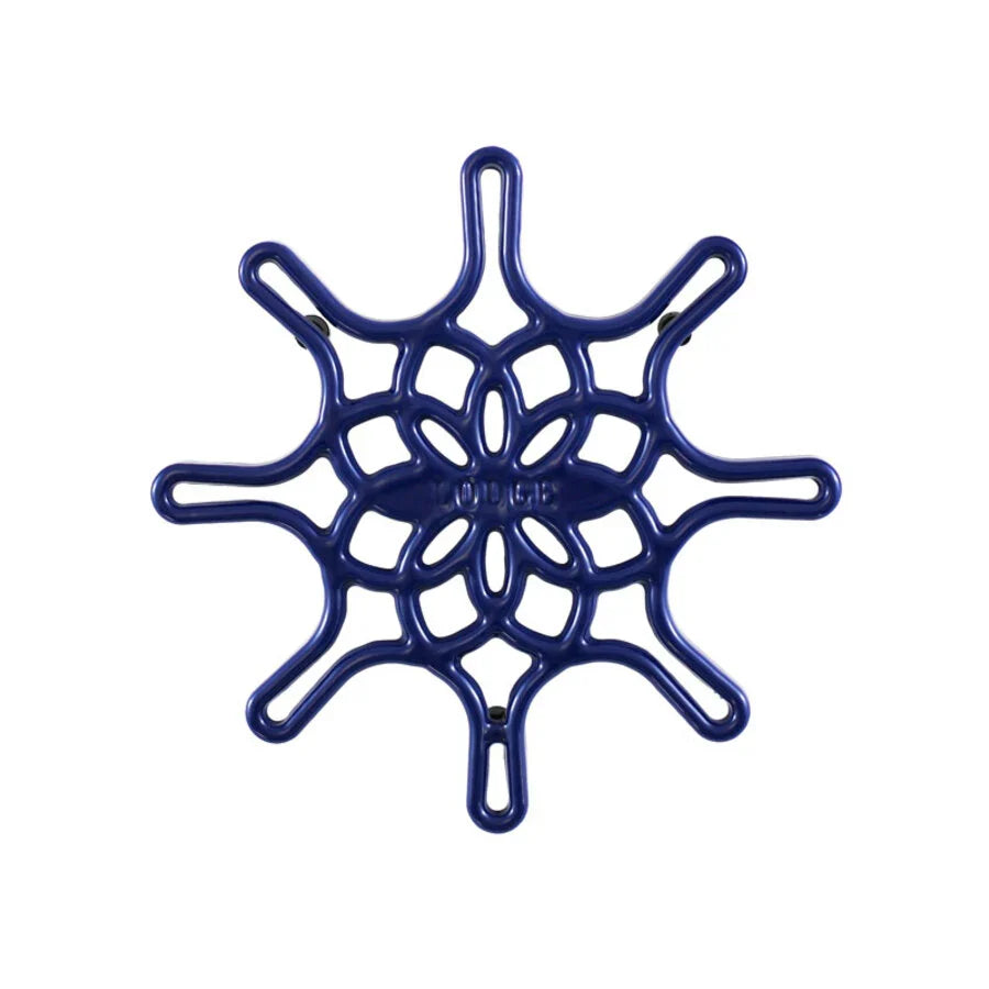 An indigo enameled cast iron trivet with a geometric snowflake-like pattern.