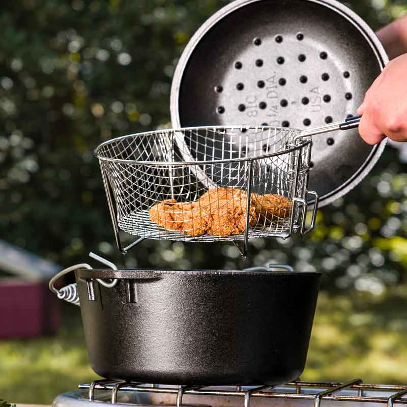Someone taking out freshly fried food from dutch oven.