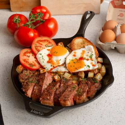 Steak, potatoes, and eggs, served in cast iron skillet.