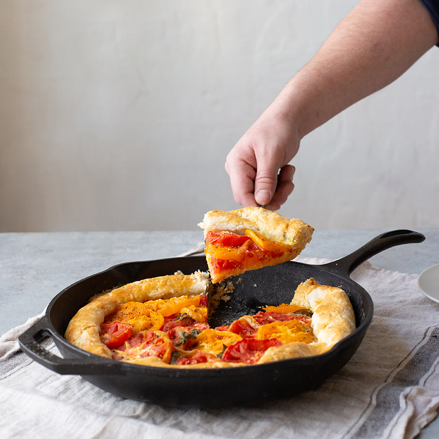 Fresh tomato pie being served from skillet.