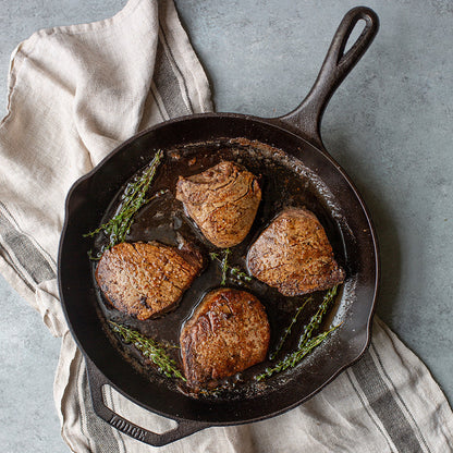Filet mignon prepared in skillet, served on counter.