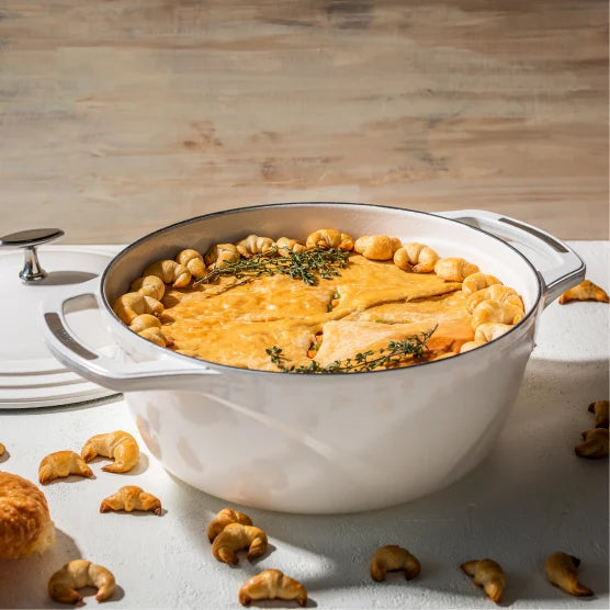 Our croissant-crust chicken pot pie, prepared in dutch oven, on table surrounded by mini croissants.