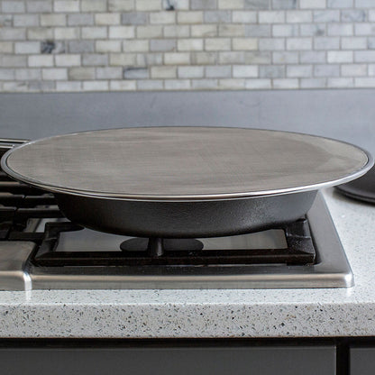 Someone using screen while cooking on stove with skillet.